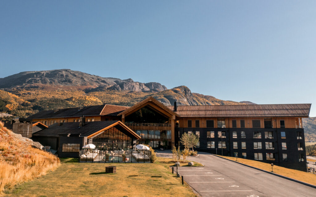 Fyri resort hotellfasade, utebasseng, fjell i bakgrunnen.
