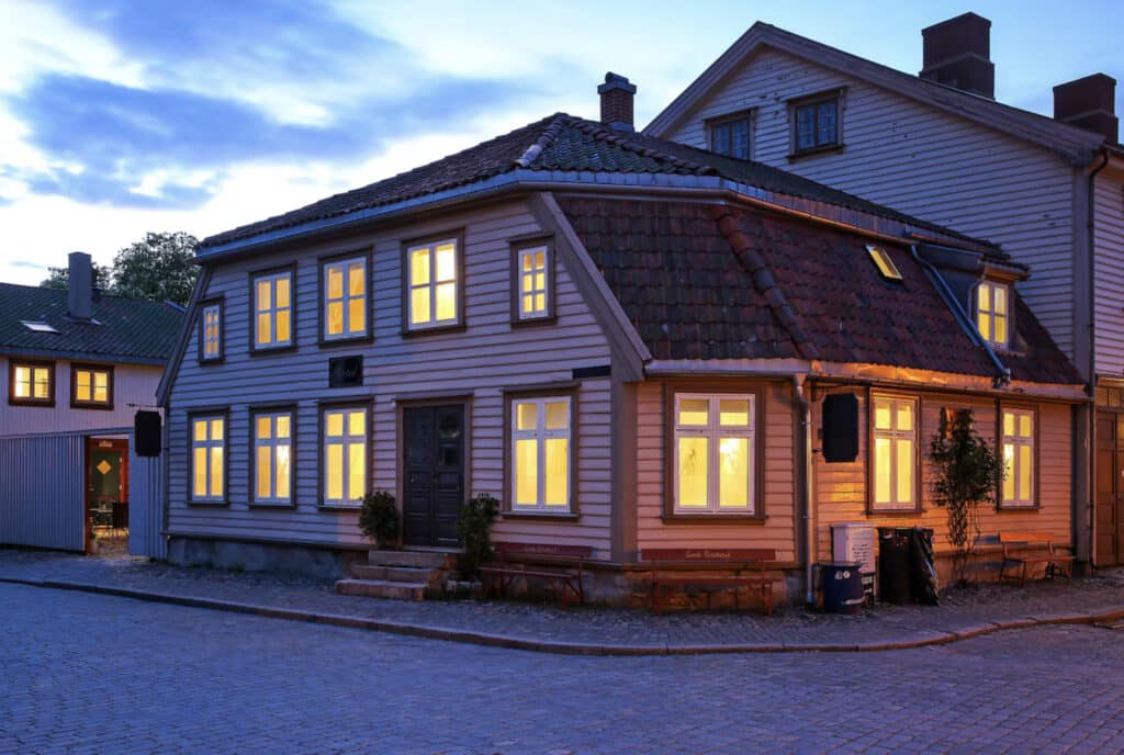 Hotellet utenfor, mørkt og lys inne.