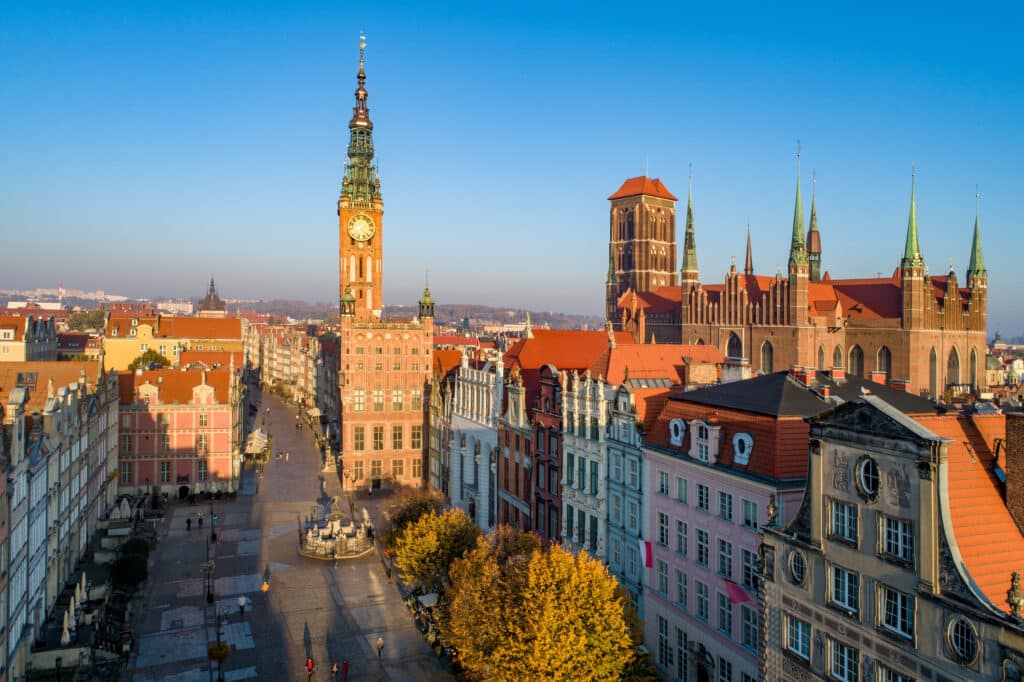 Polen. Gdańsks gamleby med skyline som inkluderer den middelalderske gotiske Mariakirken, rådhuset med klokketårn, Dluga-gaten og Neptun-statuen med fontenen. Utsikt fra luften i soloppgangens lys om høsten.