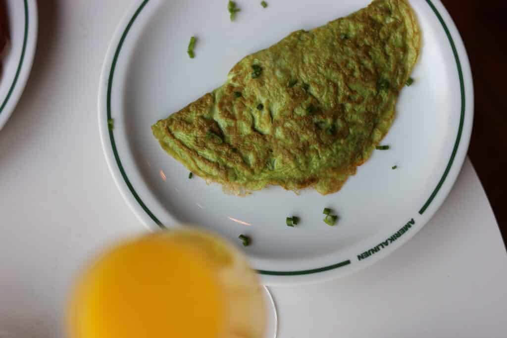 Omelett på talleren med appelsinjuice ved siden av. 