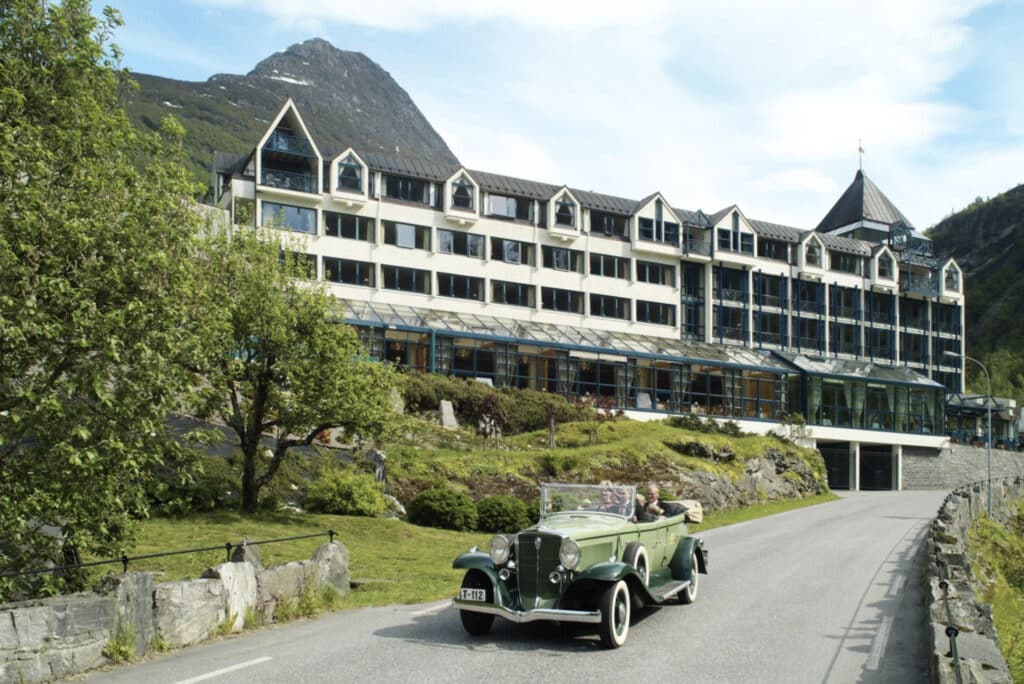 Hotellet utenfor med gammel bil kjørende.