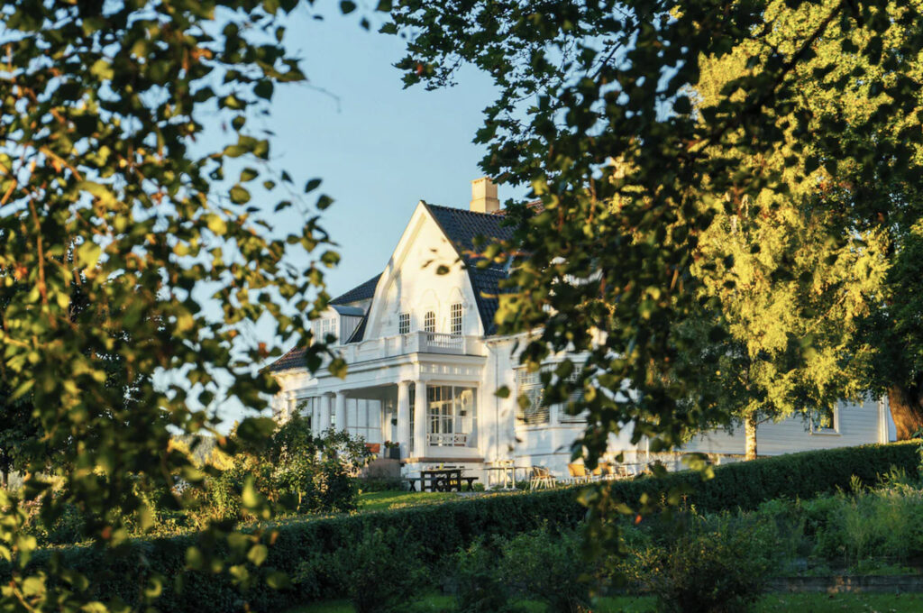 Villa-hotell med grønne trær.
