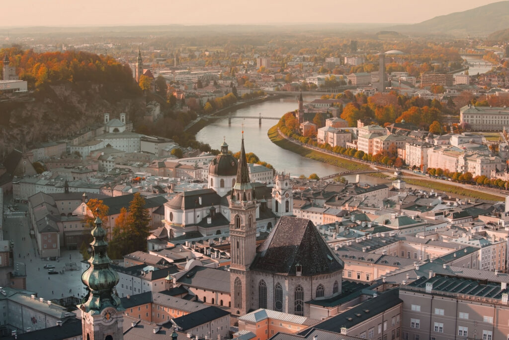 Vakker utsikt i høstsesongen over den historiske byen Salzburg med elven Salzach, i et gyllent kveldslys med himmel ved solnedgang og høstens farger i Salzburger Land, Østerrike.