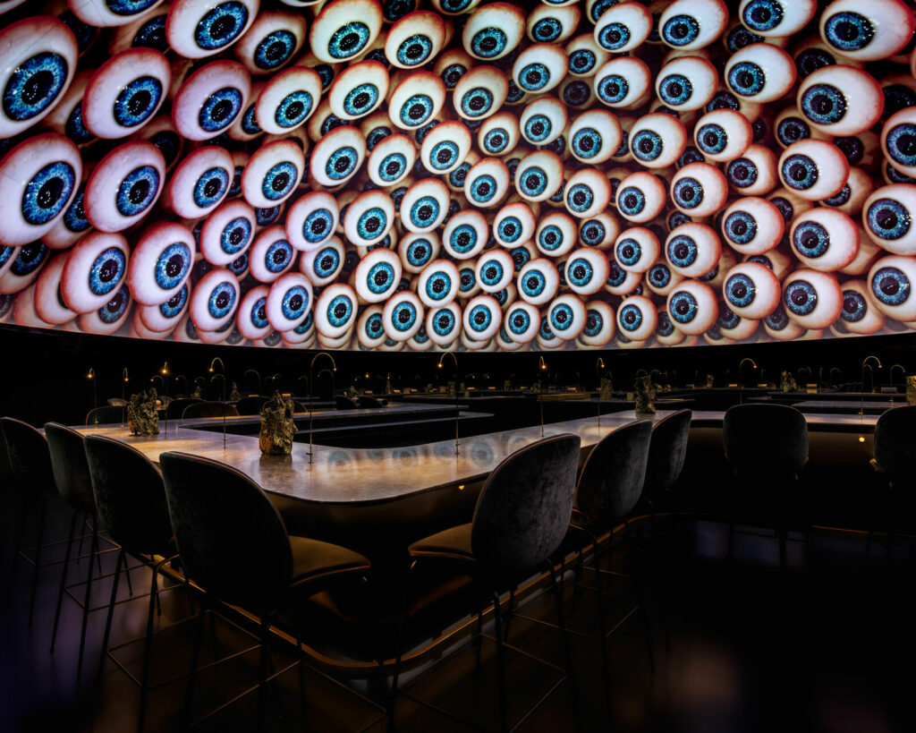 Restaurant som ser ut som en dome med mange små øyer på veggene og mørk atmosfære.
