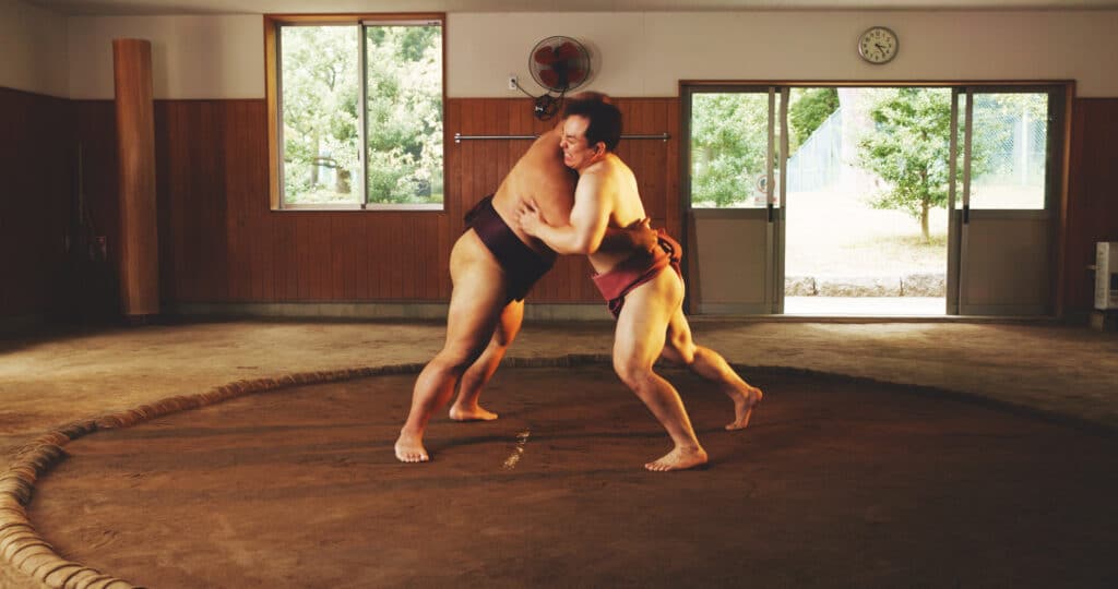 Kamp, slåssing eller sumobryting mellom menn i dohyo under en japansk konkurranse, kulturarrangement eller turnering. Trening, styrke og teknikk står i fokus når brytere møtes i ringen for en oppvisningskamp.