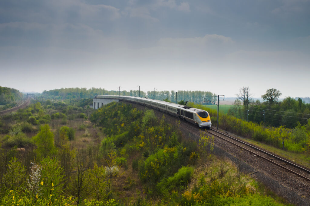 Coubert, Frankrike, 12. april 2014: Et Eurostar-høyhastighetstog krysser mellom to skogsområder.
