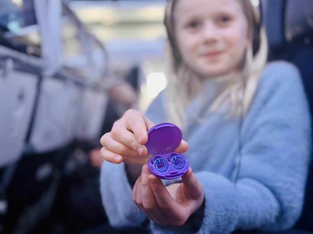 barn som holder ørepropper 