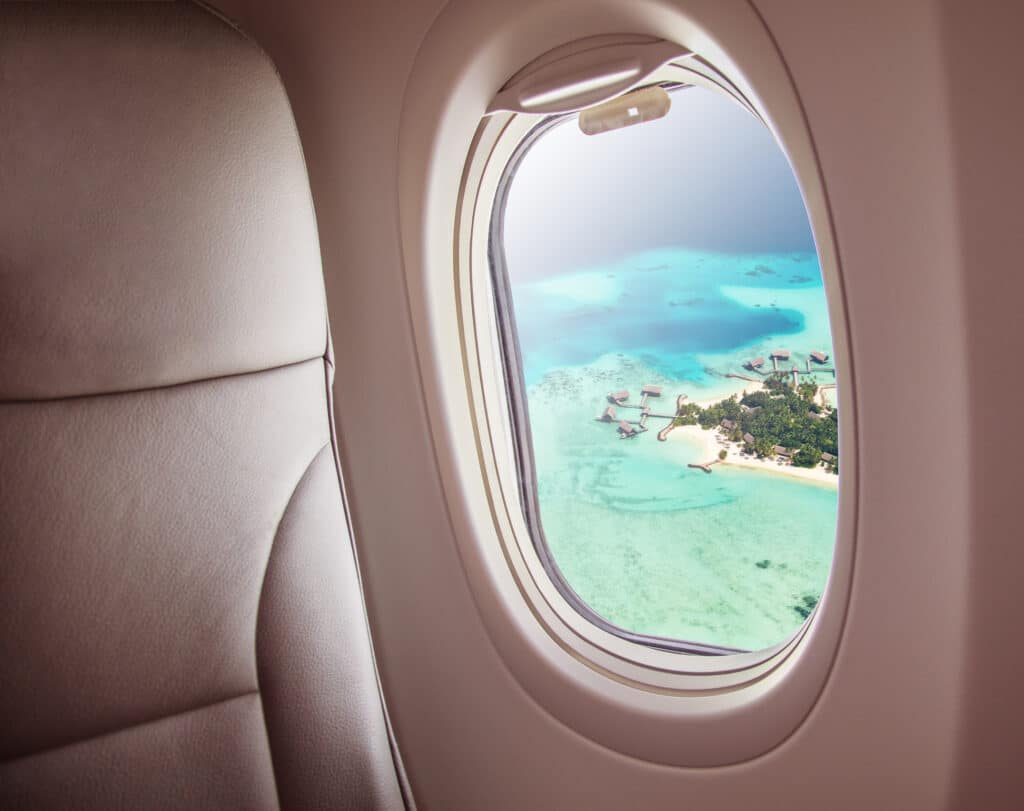 Fly i lufta som viser vindu og utsikt med øyer og strand