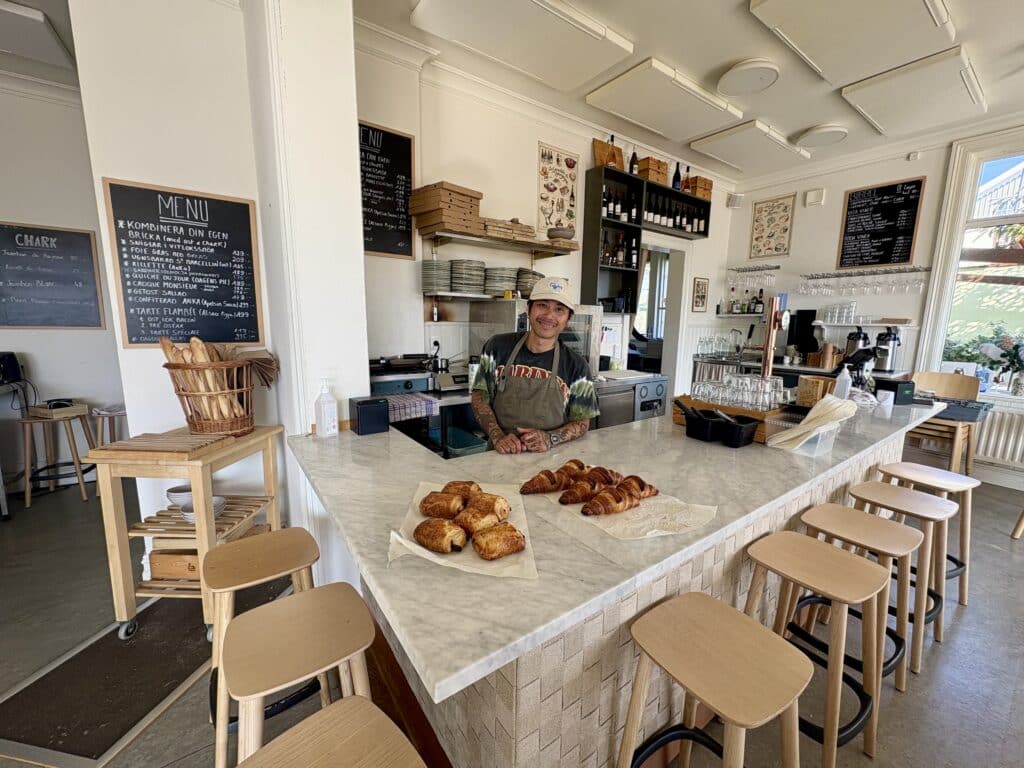 ansatt på spisestedet Le Comptoir står i kassa