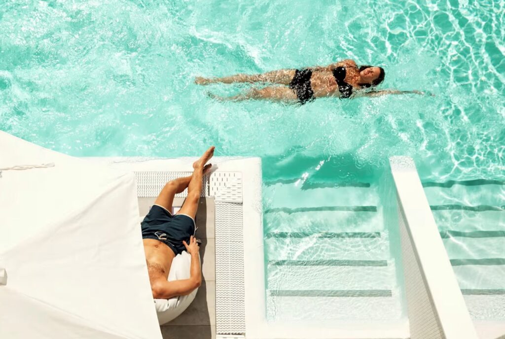 To personer svømmer i basseng på ocean beac club på gran canaria